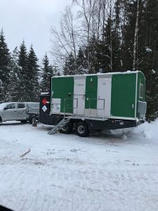 grön depåvagn med vita dörrar som står på snötäckt mark