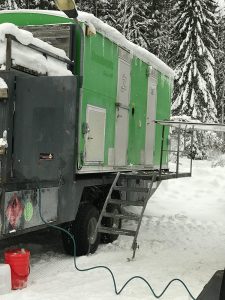 närbild på grön depåvagn som står på snötäckt mark